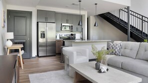 A modern kitchen with grey cabinets, stainless steel appliances, and a central island. - Landing | Amazing 1BD, Courtyard, Gym (Atlanta)