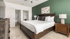 A bedroom with a bed, bedside tables, a dresser, and a ceiling fan. - Landing | Spectacular 2BD, Pool, Gym (Port Charlotte)