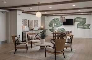 A spacious living room with a dining area, featuring a large wall mural, a flat-screen TV, and a modern chandelier. - Landing | Spectacular 2BD, Pool, Gym (Port Charlotte)