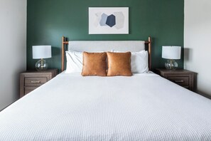 A neatly made bed with two pillows, a headboard, and two bedside tables with lamps. - Landing | Stunning 1BD, Gym (Destin)