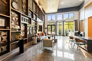 A spacious living area with a modern design, featuring a large sofa, a coffee table, and a dining area with chairs. - Landing | Stylish 1BD, Clubhouse, Rooftop Lounge (Fort Worth)
