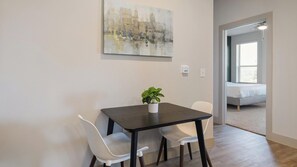 A dining area with a table, chairs, and a potted plant. - Landing | Stylish 1BD, Clubhouse, Rooftop Lounge (Fort Worth)