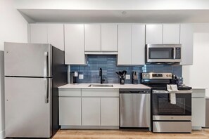 Una cocina moderna con electrodomésticos de acero inoxidable, microondas y lavavajillas.