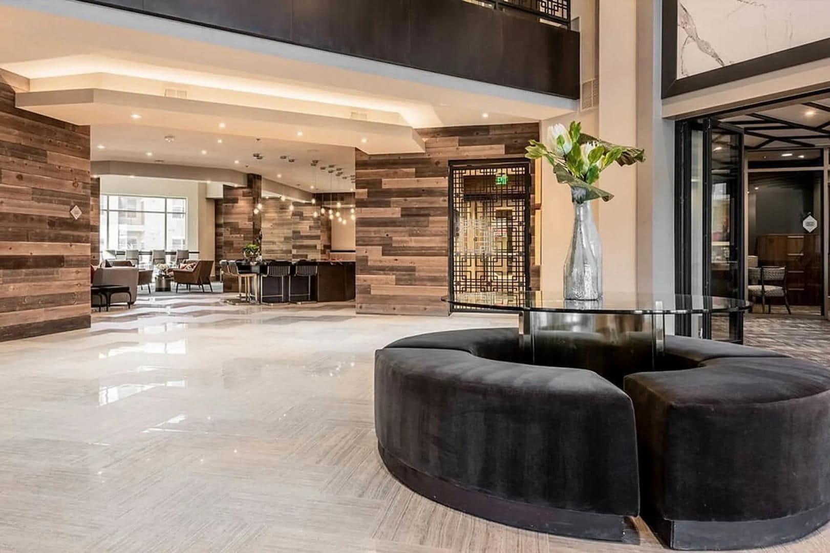 A modern lobby with a reception desk, seating area, and a decorative vase.