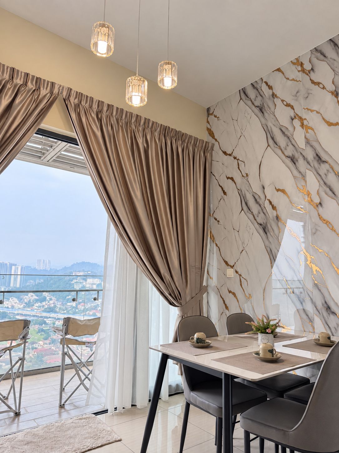 Ein moderner Essbereich mit einem Tisch für zwei Personen, Blick auf die Stadt durch große Fenster und einer Wand mit Marmormuster.