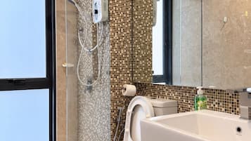 Ein modernes Badezimmer mit einer einteiligen Glasdusche, einer Toilette und einem Waschbecken.