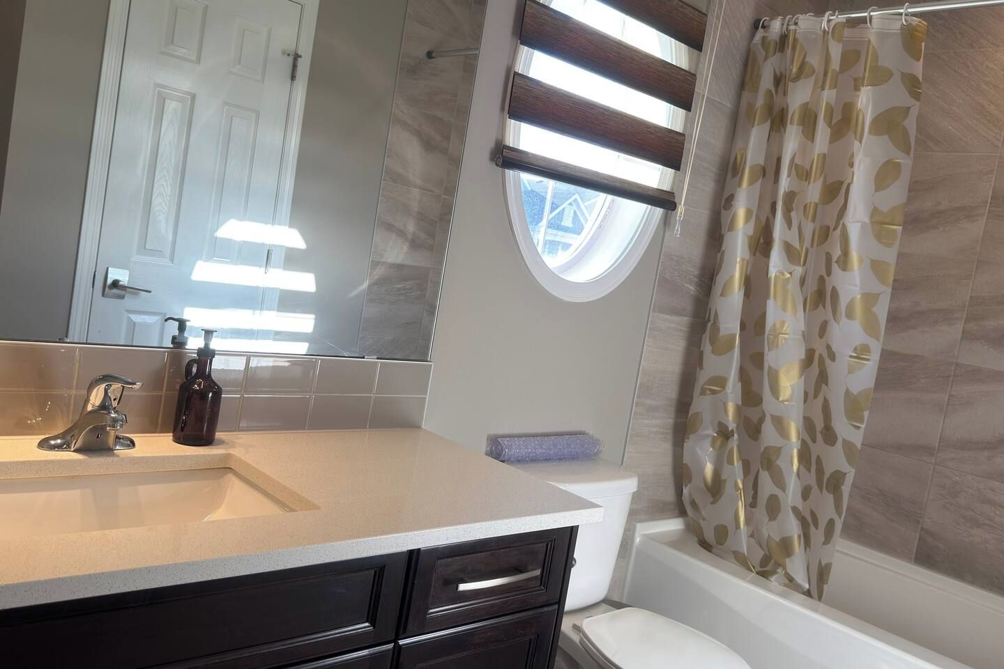 A bathroom with a sink, mirror, toilet, and bathtub.