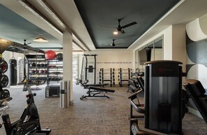 A gym with various exercise equipment, a wall with motivational text, and a ceiling fan. - Landing | Stylish 1BD, Pool, Game Room (Gainesville)