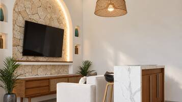 A modern living room with a stone wall, flat-screen TV, wooden furniture, and a marble accent wall.