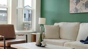 En stue med sofa, sofabord, lampe og en plante.