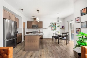 A modern kitchen with stainless steel appliances, wooden cabinets, and a central island.