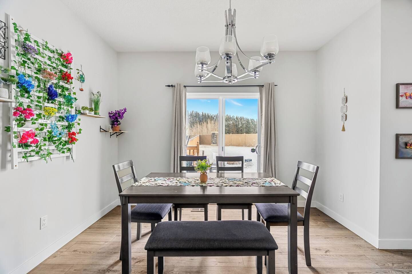 Espaço de refeições com mesa, cadeiras e lustre.