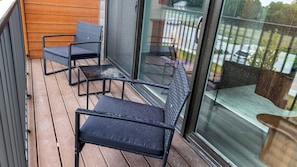 A balcony with two chairs and a table. - Landing | Incredible 1BD, Gym (Council Bluffs)