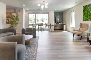 A spacious living area with a dining set, a kitchen in the background, and a large window providing natural light. - Landing | Beautiful 1BD, Gym (Council Bluffs)