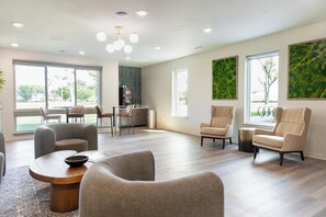 A spacious living area with a modern kitchen in the background, large windows, and a ceiling with recessed lighting. - Landing | Incredible 1BD, Gym (Council Bluffs)
