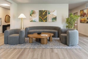 A modern living room with a grey sectional sofa, a wooden coffee table, and a patterned rug. - Landing | Incredible 1BD, Gym (Council Bluffs)