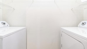 A laundry room with two white washing machines and a metal drying rack. - Landing | Stunning 1BD, Gym, Clubhouse (Jacksonville)