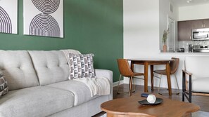 Ein Wohnzimmer mit einer Couch, einem Couchtisch und einem Essbereich mit Stühlen und einem Tisch.