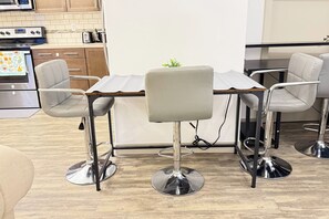 Une cuisine moderne avec un coin repas comprenant deux tabourets de bar et une table.