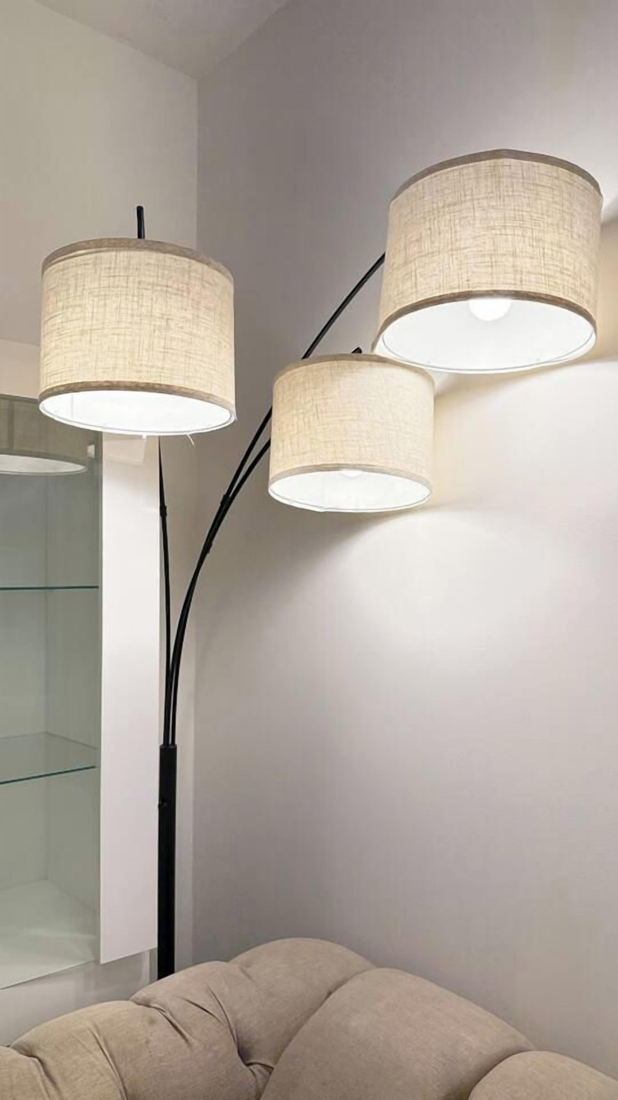 A modern interior with a glass partition and three wall-mounted lamps.