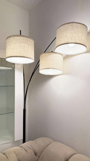 A modern interior with a glass partition and three wall-mounted lamps.