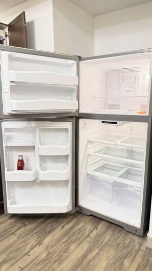 A modern kitchen with a built-in refrigerator and a microwave.