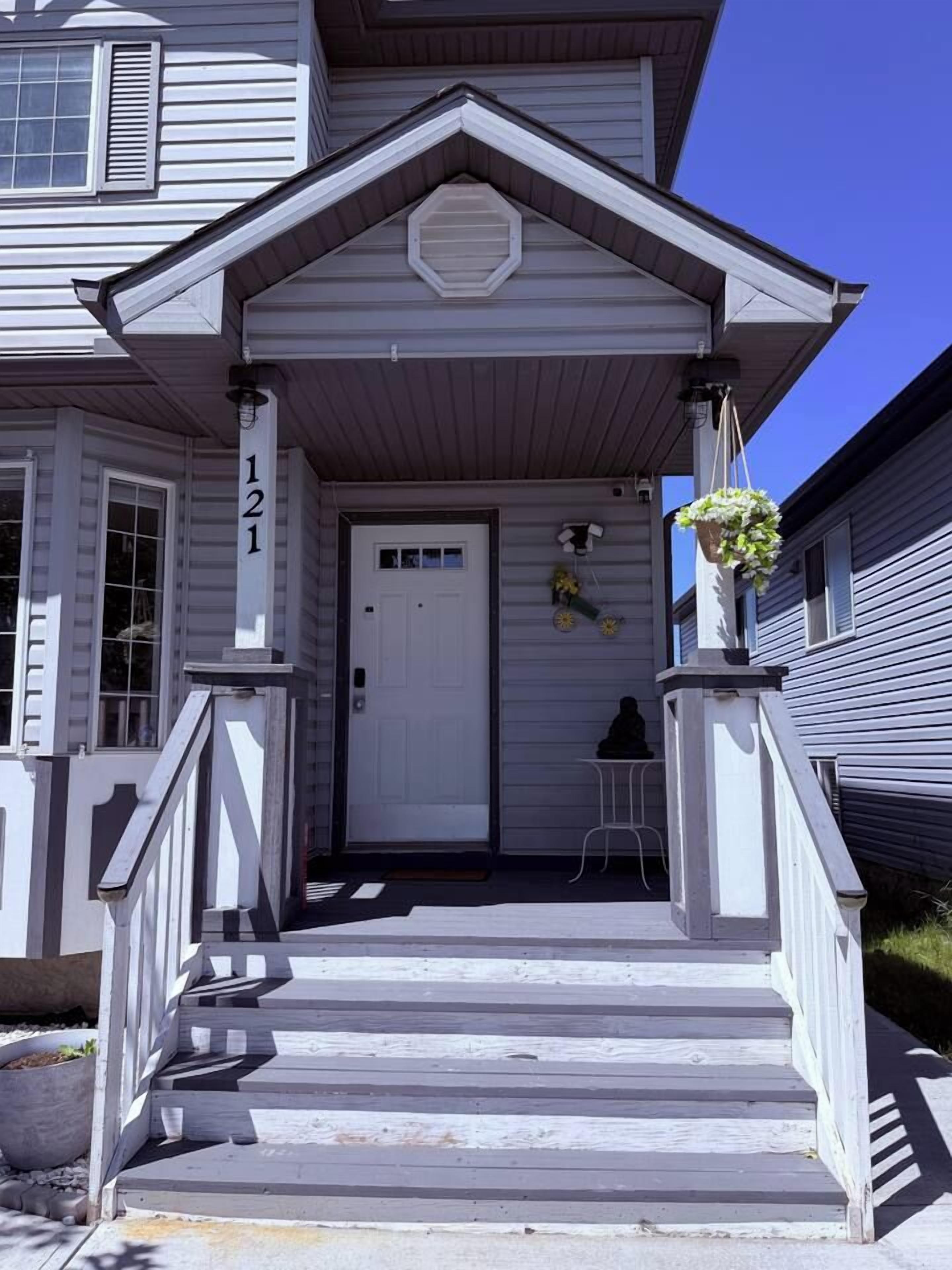 A two-story house with a front porch, a door, and a mailbox.