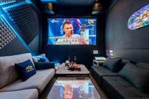 Un espace de détente moderne doté d’un grand écran, de canapés, d’une table basse et d’un mur insonorisé.
