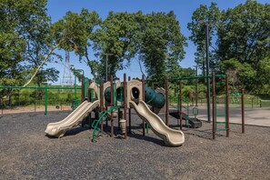 A playground with slides and climbing structures. - Landing | Chic 1BD, Gym (Bridgeport)