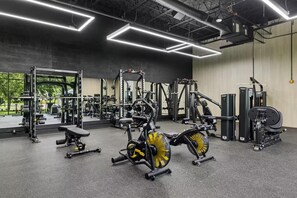 A gym with various exercise equipment, a bench, and a mirror reflecting the space. - Landing | Beautiful 2BD, Gym (Bridgeport)