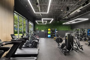 Une salle de sport équipée de tapis de course, de ballons d'exercice et d'appareils de musculation.