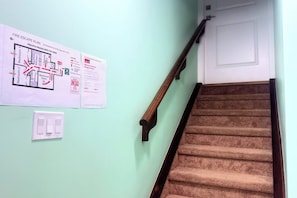 Fluchtplan an einer Wand, ein Satz Teppichstufen und ein Lichtschalter.