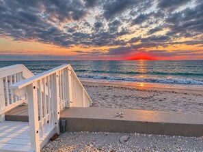 A wooden deck leading to a beach with a sunset in the background. - La Coquina 2BR Beachfront - Gulf Views + Pool (Englewood)