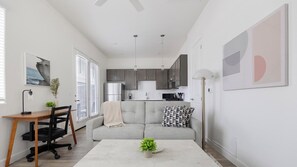 A modern apartment with a dining area, kitchenette, and a living space with a sofa and coffee table. - Landing | Stylish 1BD, Gym, Pool (Maricopa)