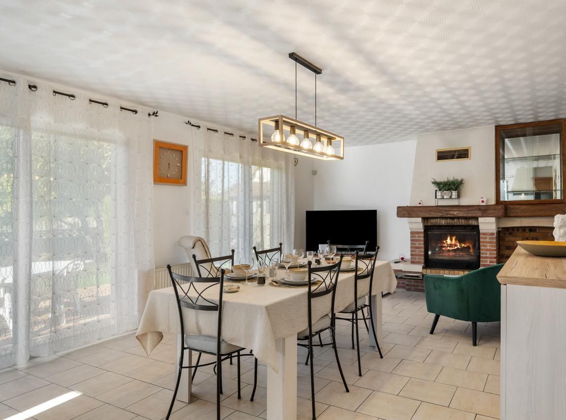 Grande pièce de vie avec cuisine ouverte. Coin salon avec une grande télévision connectée et une belle cheminée.