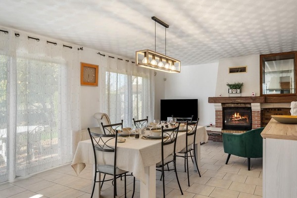 Grande pièce de vie avec cuisine ouverte. Coin salon avec une grande télévision connectée et une belle cheminée.