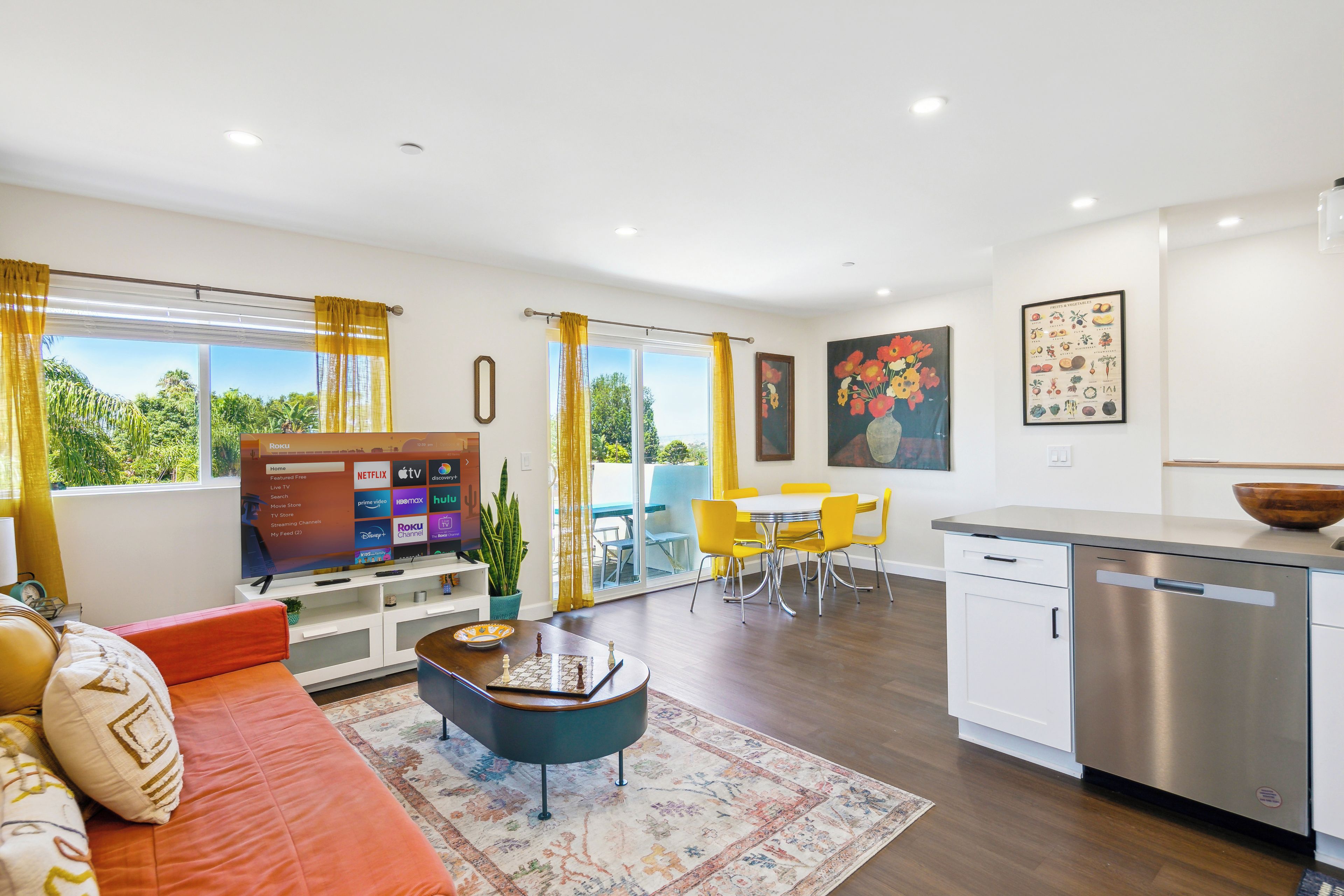 Un salon moderne avec un canapé, une table basse et un téléviseur à écran plat.