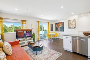 Un salon moderne avec un canapé, une table basse et un téléviseur à écran plat.
