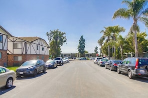 Une rue bordée de voitures garées et d’immeubles d’habitation.