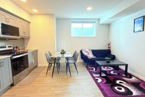 A compact living space with a kitchenette, dining area, and seating area. - Cozy Queen Suite|Private Basement (Calgary)