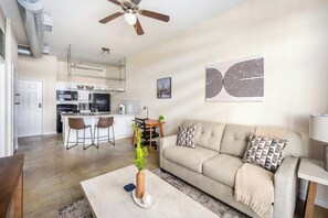 Uma sala de estar moderna com sofá, mesa de centro e área de jantar com cadeiras.