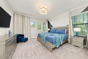 A bedroom with a bed, a desk, a chair, a TV, and a window with blinds. - Theater Area | Games Area | Private Pool (Davenport)