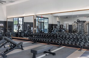 A gym with exercise equipment, a bench, and a mirror reflecting the space. - Landing | Incredible 2BD, Gym, Game Room (Cape Coral)