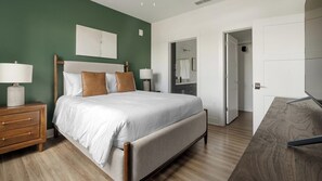 A modern bedroom with a bed, nightstands, a dresser, and a walk-in closet. - Landing | Incredible 2BD, Game Room, Gym (Cape Coral)