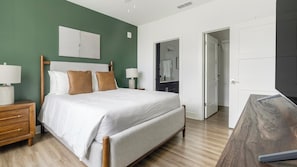 A bedroom with a bed, bedside tables, a nightstand, a mirror, and a wardrobe. - Landing | Modern 2BD, Gym, Game Room (Cape Coral)