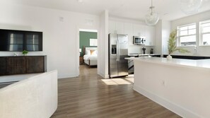 Una cocina moderna con una isla grande, electrodomésticos de acero inoxidable y un televisor de pantalla plana montado en la pared.