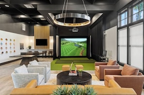 A modern lounge area with a large screen, comfortable seating, and a stylish ceiling design. - Landing | Stylish 2BD, Game Room, Gym (Cape Coral)