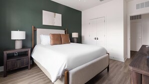 A neatly arranged bedroom with a bed, bedside tables, and a wardrobe. - Landing | Incredible 1BD, Gym, Game Room (Cape Coral)
