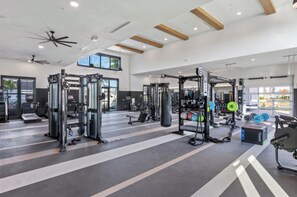 A gym with various exercise equipment, including treadmills, weight machines, and free weights. - Landing | Incredible 1BD, Gym, Game Room (Cape Coral)