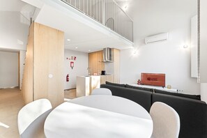 A modern living room with a dining area, a kitchen, and a staircase. - GuestReady-Rou27-G (Porto)